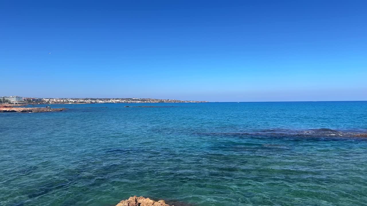 View of calm blue waters and distant shoreline in Crete Greece under a clear blue sky
