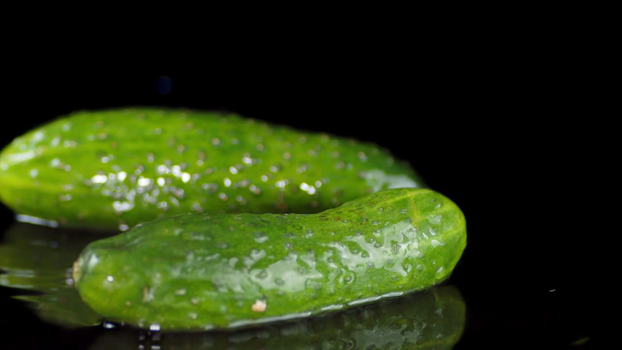 Whole cucumbers fall to the water with a splash.