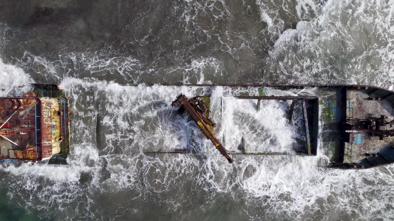 Relitto arrugginito parzialmente sommerso tra le onde dell'oceano vicino a Puerto Viejo-Manzanillo, Costa Rica - ripresa aerea.