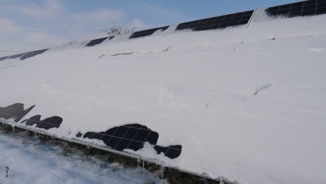 una capa de nieve en los paneles de una planta de energía solar