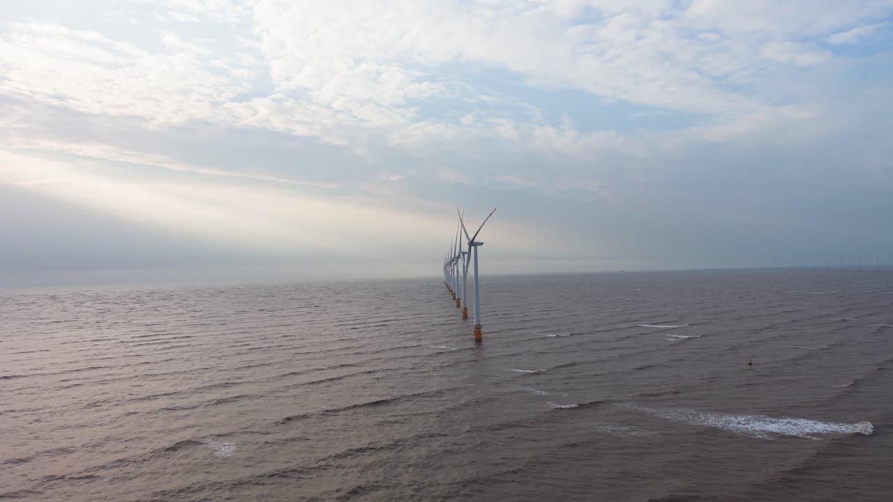 Windkraftanlagen im Meer nahe Tra Vinh, Vietnam, liefern erneuerbare Energie während der Sonnenaufgangszeiten.
