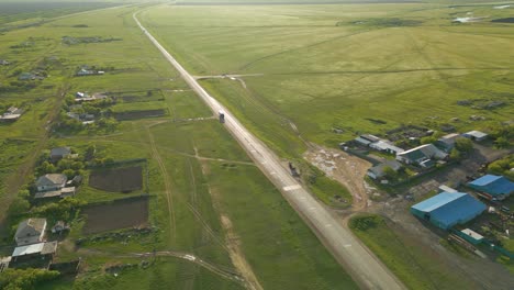 vehicles driving on rural road through residential acreage in kazakhstan