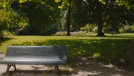 Outdoor-Bench-In-French-Style-In-A-Park-During-Spring-Season---wide-shot
