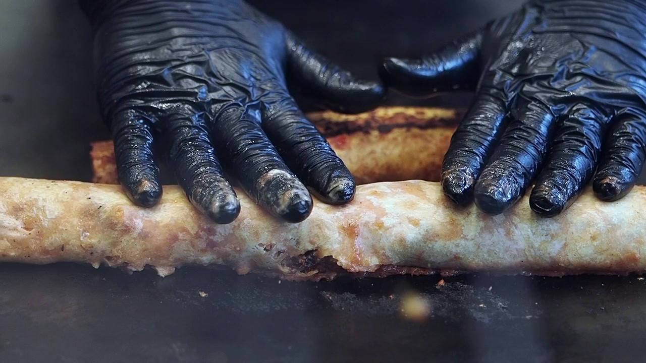 Koch brät Burritos auf einer heißen Plancha-Grillplatte
