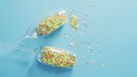 Champagne glasses with confetti on blue background at new year&#039;s eve