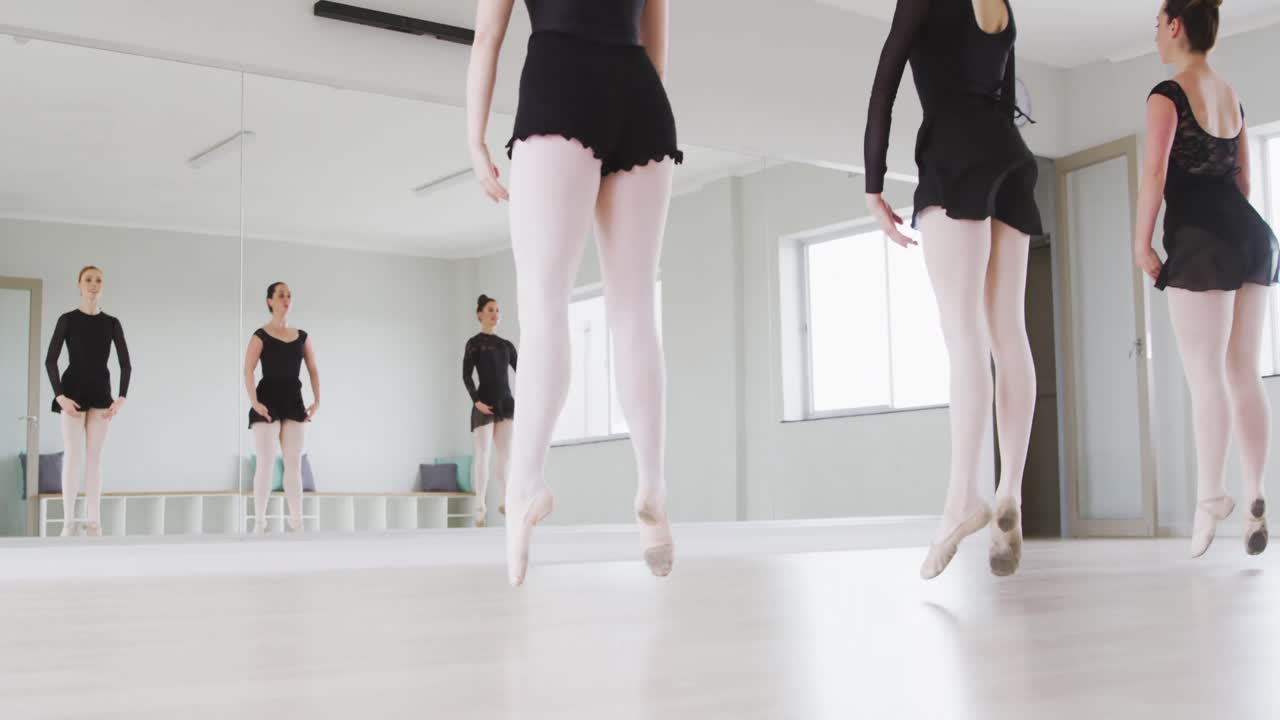 Caucasian female ballet dancers practicing a dance routine during a ballet class