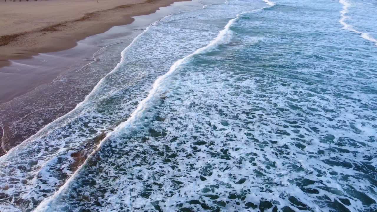 Onde del mare blu 4K. Spiaggia sabbiosa