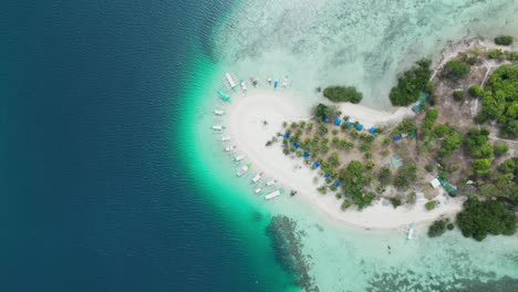 Colorful-Tour-Boats-Moored-Around-Pass-Island-Sandbank-in-Coron,-Aerial