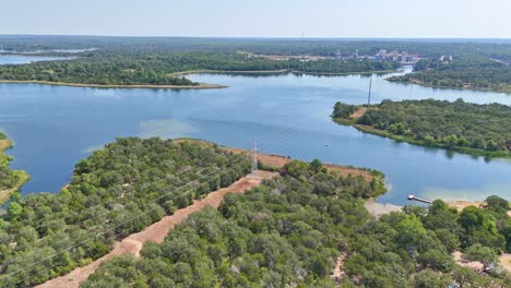 Moving-quickly-to-the-left-above-a-pretty-blue-lake-and-recreational-area-that-has-a-fishing-dock