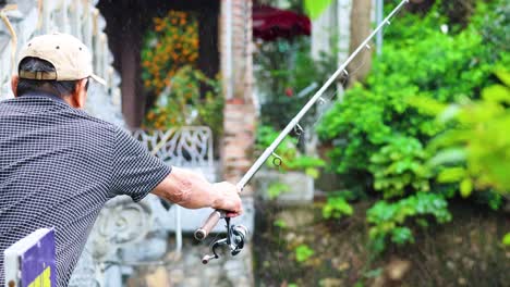 man fishing near lush greenery and ornate architecture