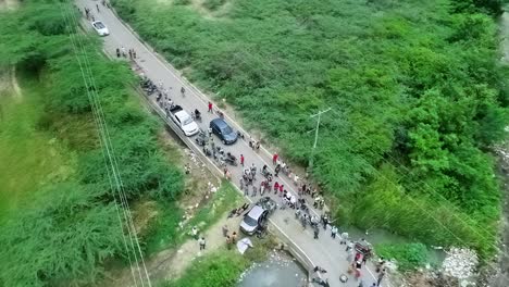 aerial view overlooking a crowd watching injured people, due to a traffic accident, in asia - rising, drone shot