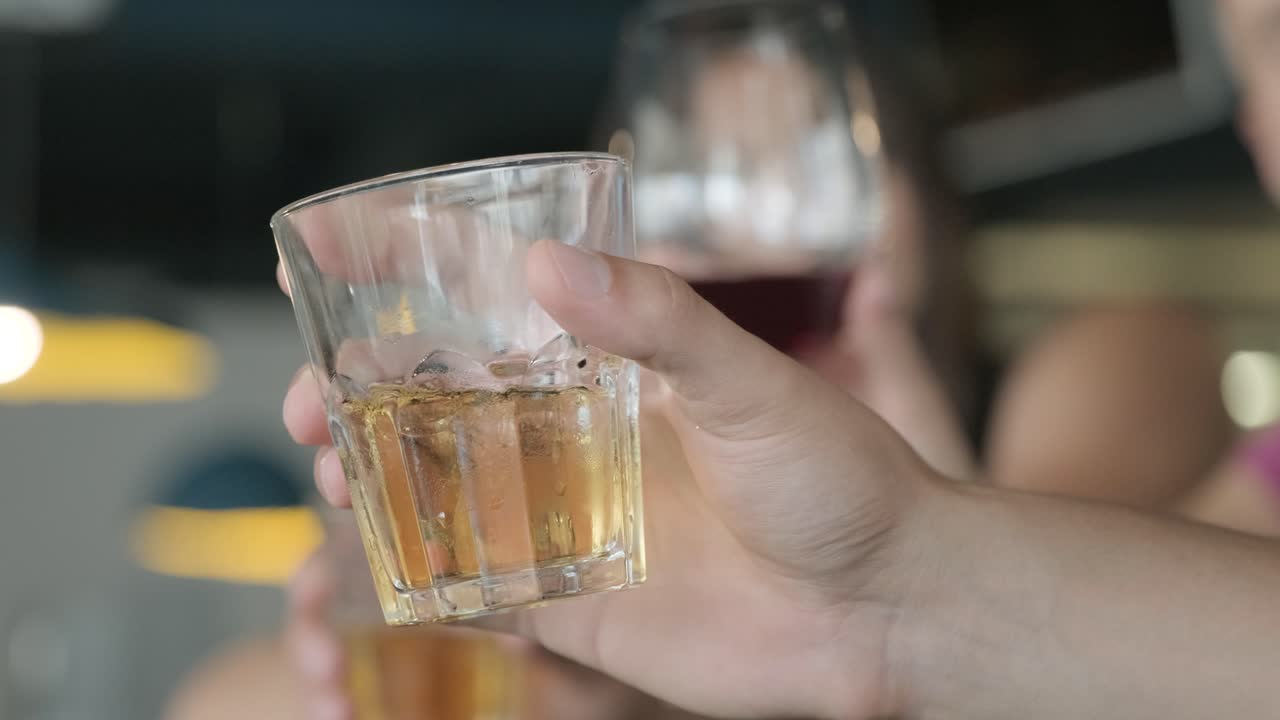 un vaso de alcohol y amigos en el bar
