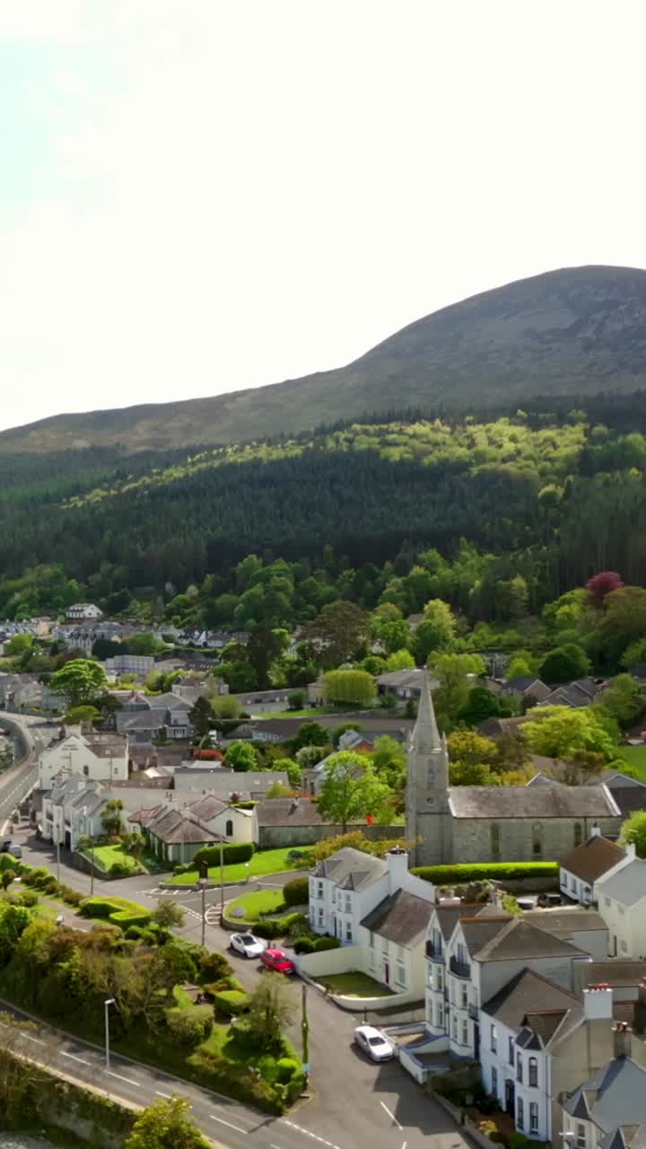 Video aereo dinamico in formato social delle Montagne Mourne a Newcastle, Contea di Down, in una luminosa giornata estiva. Prodotto a 60fps, in formato social 1080x1920 e con colore Rec709.
