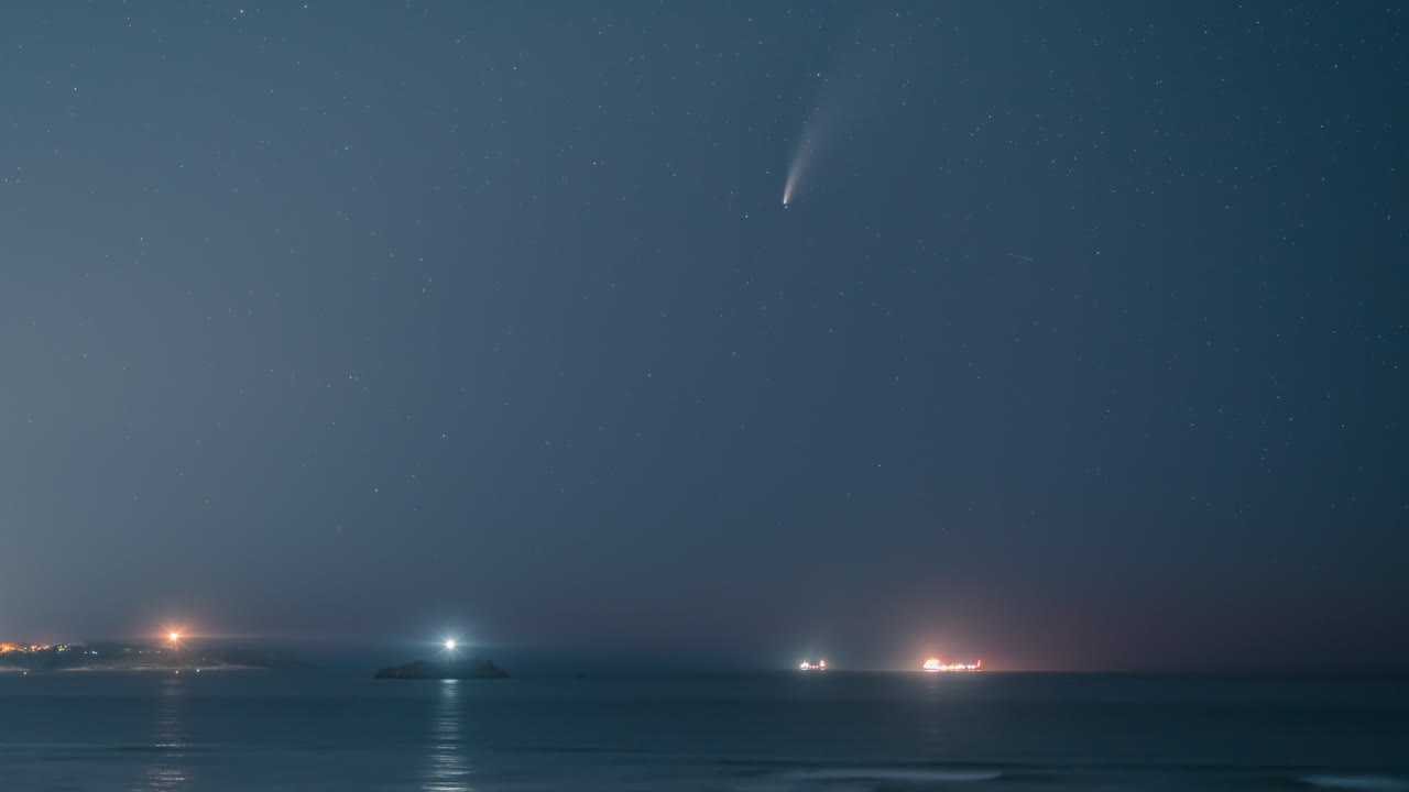 cometa neowise sobre 2 faros y barcos en santander, cantabria, españa