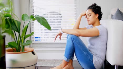thoughtful woman sitting near sofa in living room 4k