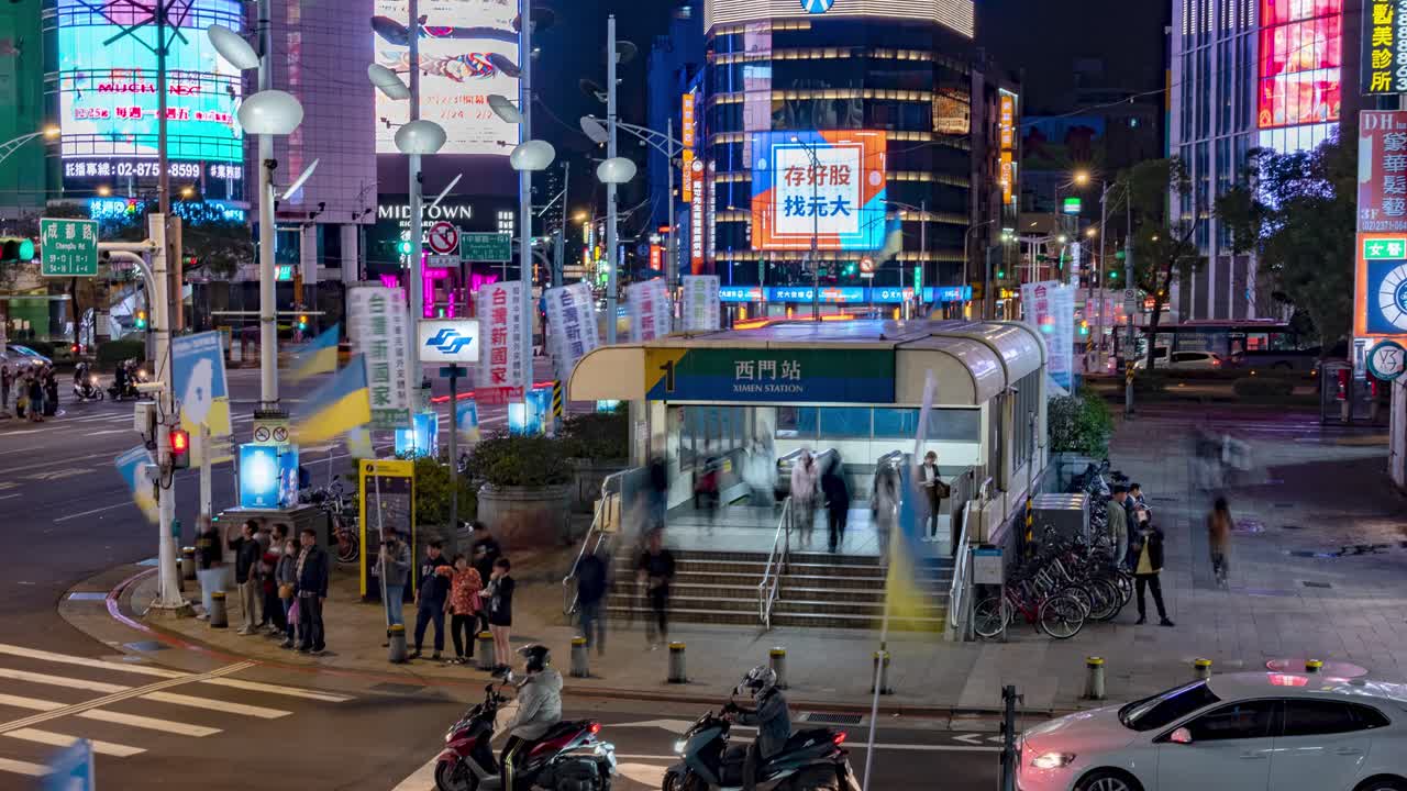 Timelapse of a busy crowds entering Ximen station as traffic passes and with Neon city Lights at Night in Ximen District Taipei, Taiwan TILT