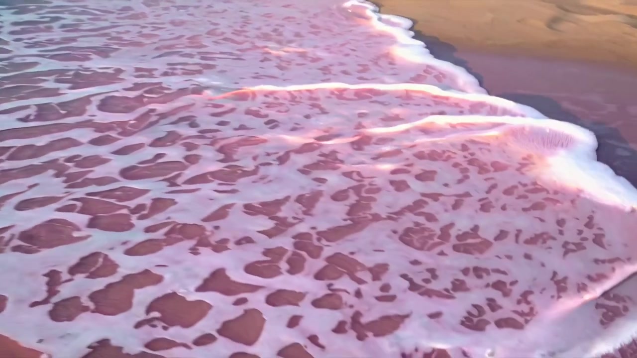 Onde oceaniche delicate che lambiscono una spiaggia di sabbia rosa