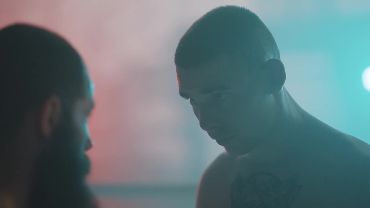 Two Men Staring Intensely in Dramatic Neon Light