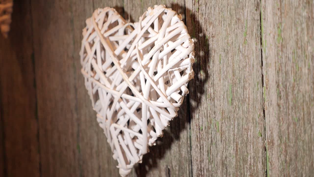 나무 벽에 걸려 있는 짠 러브 하트 장식 디자인