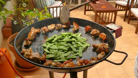 forma tradicional de preparar la paella valenciana con pollo y verduras - de cerca