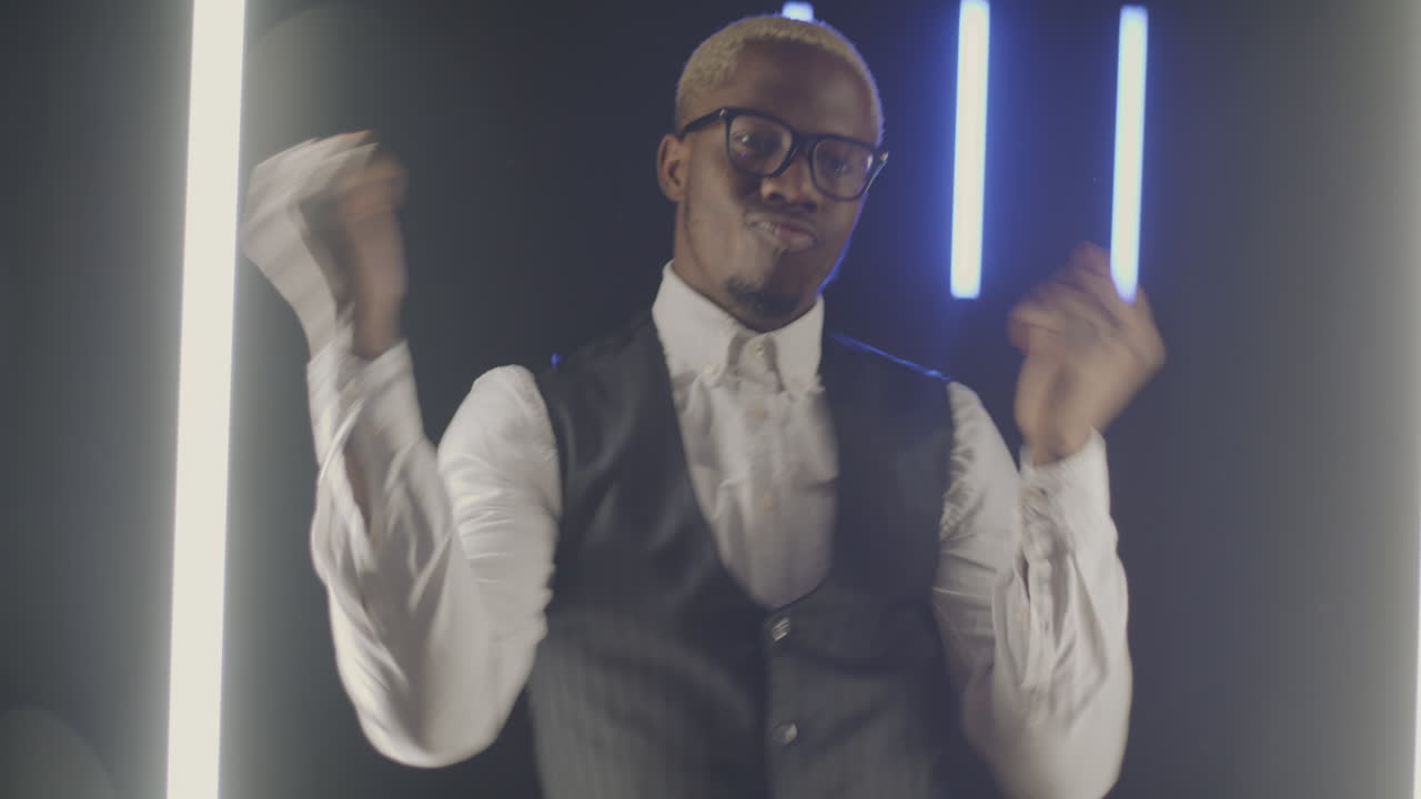 Stylish Man Dancing Under Neon Lighting