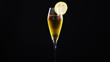 a lemon sour cocktail in a glass with lemon garnish, set against a black background, showcasing elegant simplicity
