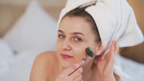 Hermosa-Joven-Haciendo-Un-Masaje-Facial-Con-Un-Masajeador-De-Rodillos-De-Jade