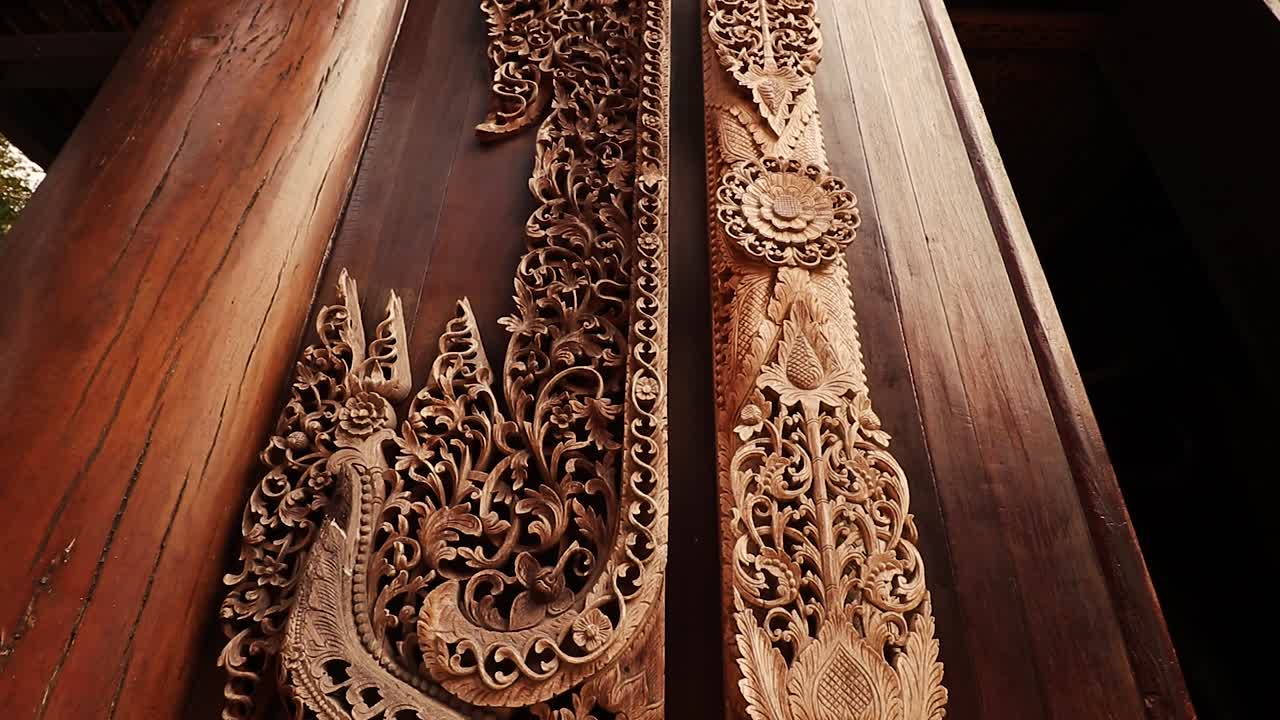 inclínate hacia arriba para elaborar tallas en la puerta de madera del museo de la presa de baan o la casa negra en chiang rai, tailandia