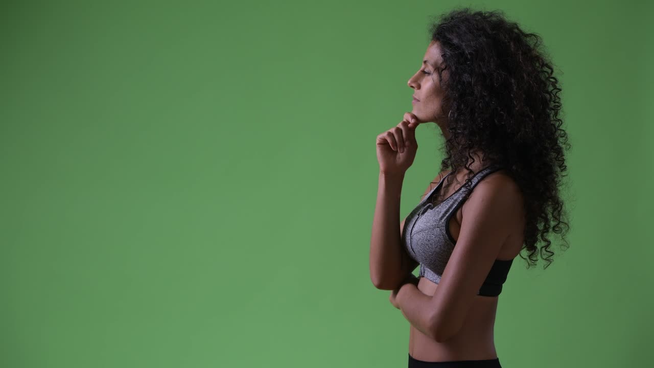 Profile view of young beautiful Hispanic woman thinking ready for gym