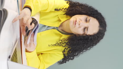 vertical video of the young woman looking at the documents is thoughtful.