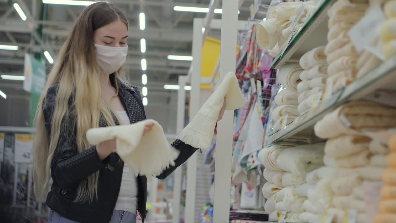 женщина покупает полотенца в супермаркете