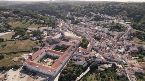 drone hovering toward historical site, alcobaca monastery complex, birds eye view