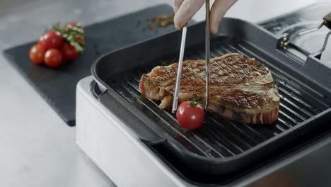 Chef-cooking-grill-steakn.-Closeup-chef-hands-putting-vegetables-at-frying-fork