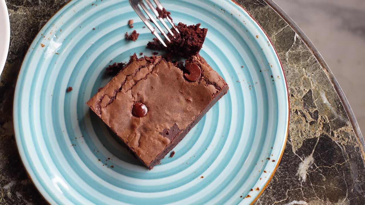 파란색과 색 접시 위에 있는 초콜릿  브라우니의 클로즈업