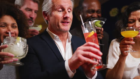 group of middle aged friends celebrating in bar together