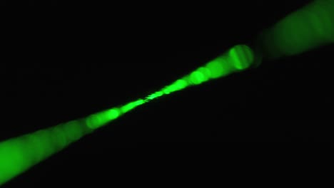rayo láser verde sobre un fondo negro. rayo láser de potencia que brilla en la niebla
