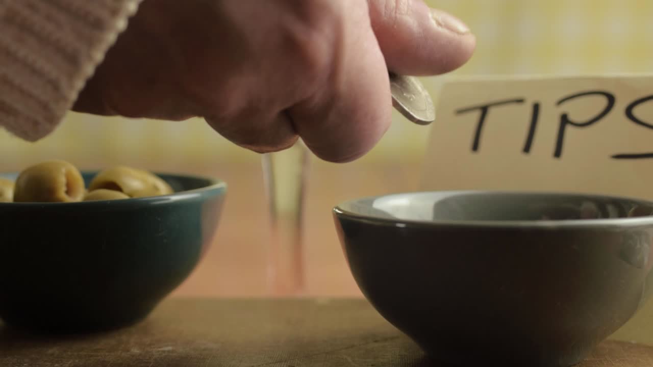 바에 현금 팁을 남기는 손 클로즈업 샷