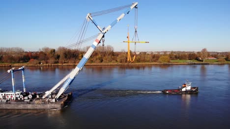 Matador-Schwimmendes-Sheerleg-Mit-Kran,-Der-Von-Einem-Schlepper-über-Den-Fluss-In-Barendrecht,-Niederlande,-Gezogen-Wird