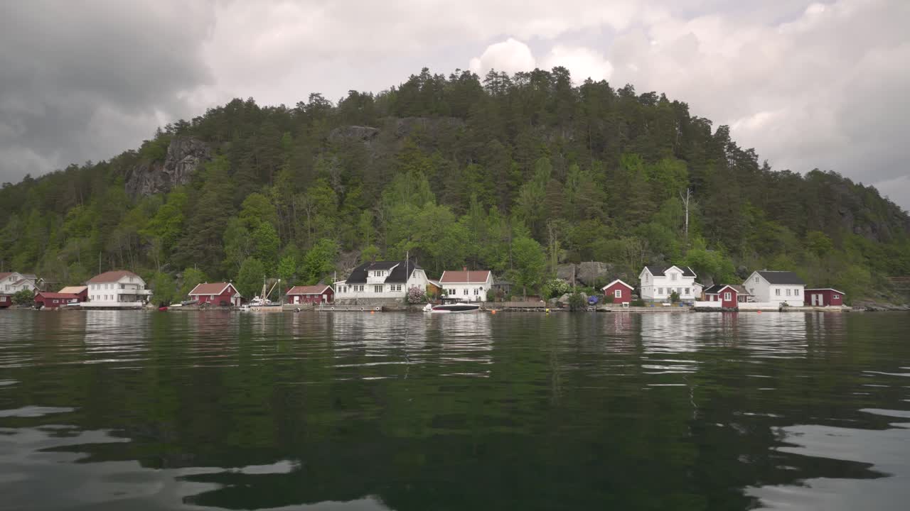 해안 옆 노르웨이 목조 주택이 거울에 비친 그림 같은 호수