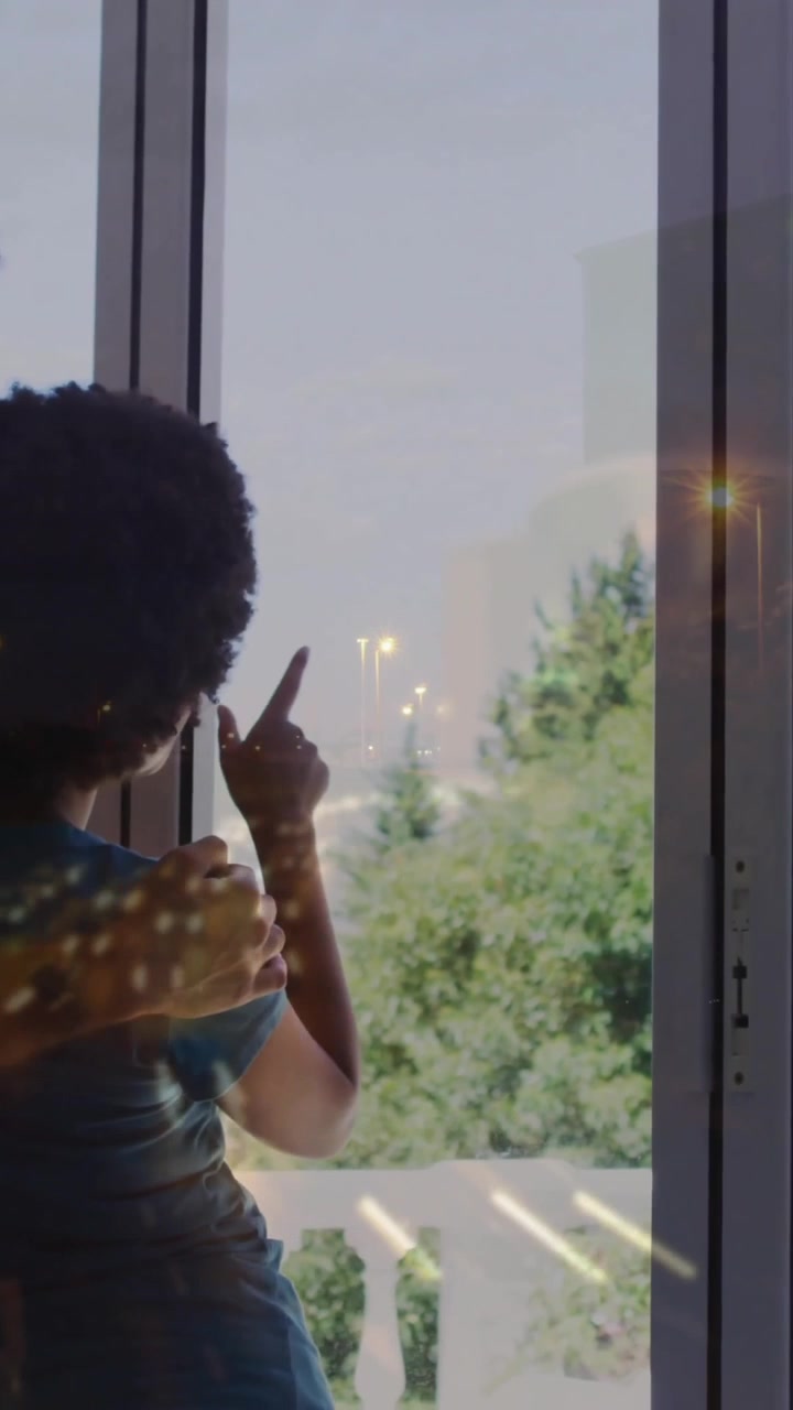 Two people looking out window at greenery with plant animation overlay