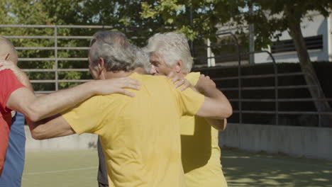 felices jugadores de fútbol senior abrazándose y saltando en círculo juntos para celebrar la victoria