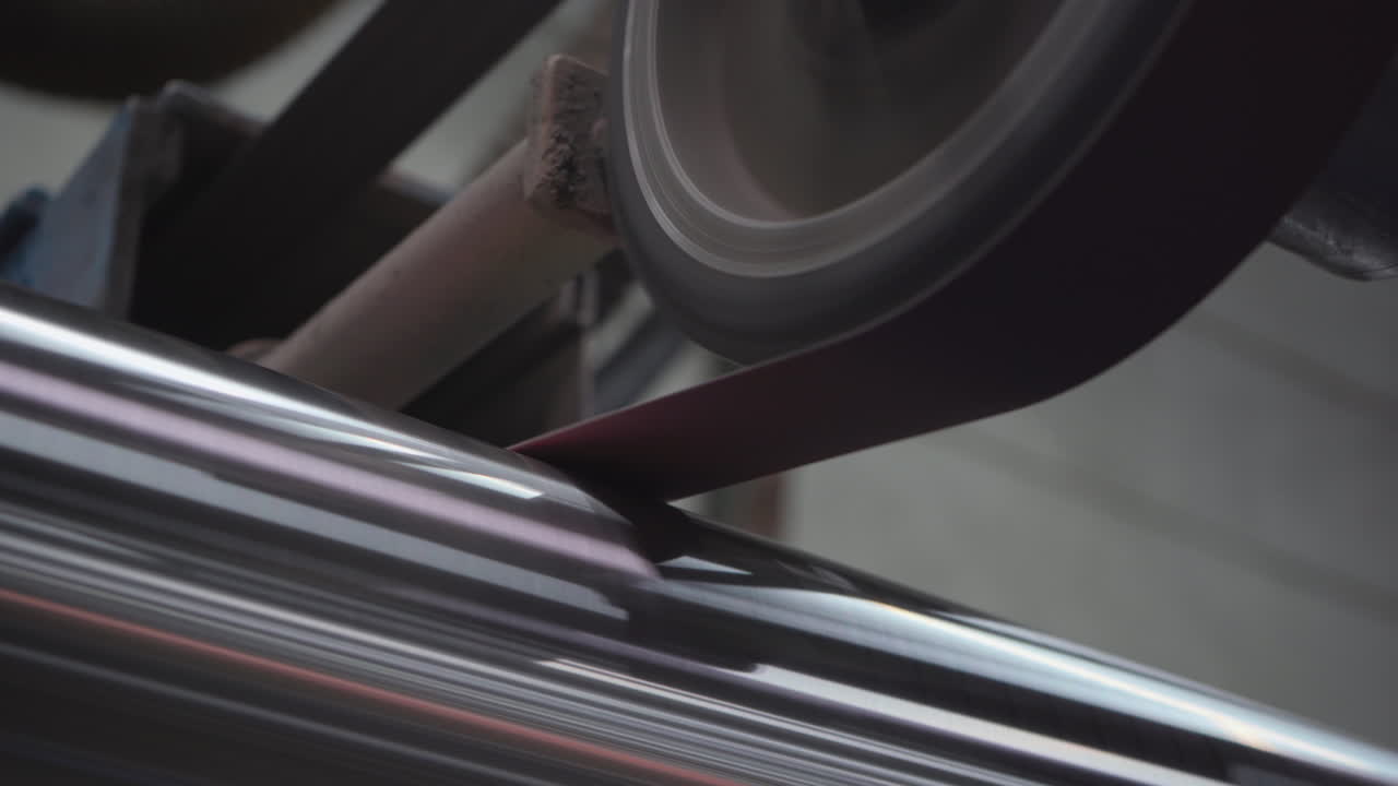 Fabbrica metalmeccanica, macchinari industriali che lucidano tubi metallici, linea di produzione