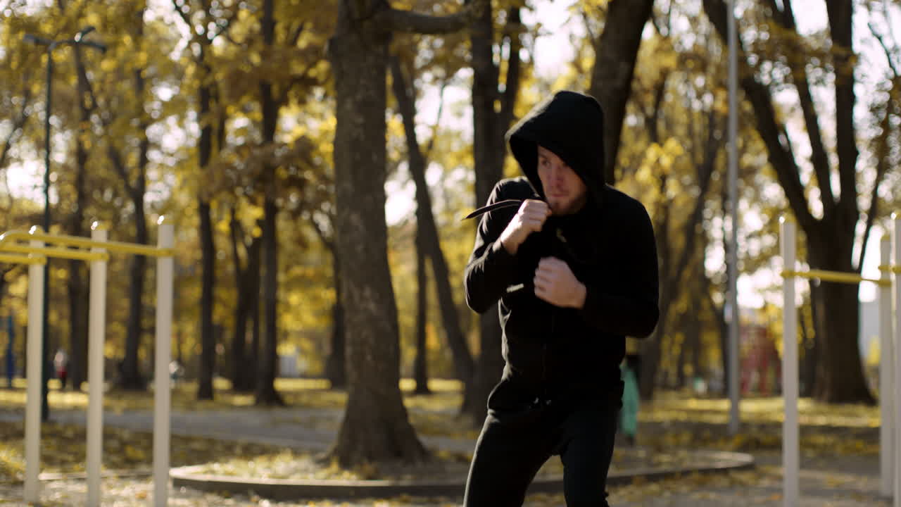 Man Boxing in Autumn Park