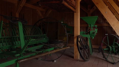 panning view of old green soil cultivator in barn