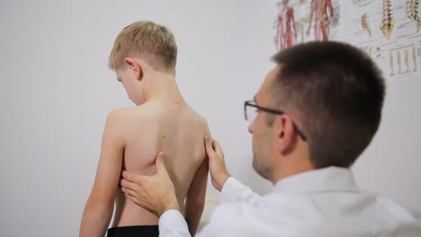 médico examinando la espalda de un niño