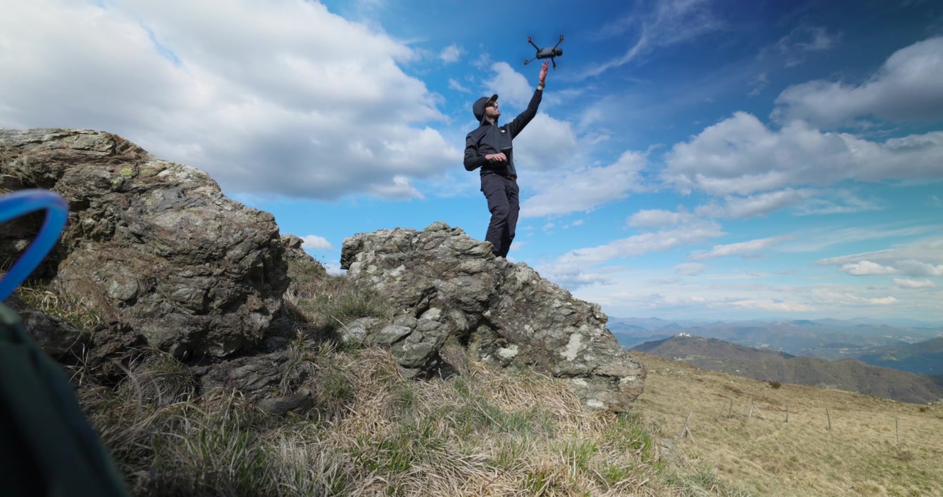 Operatore di droni che lancia un drone moderno per riprese aeree e fotografia all'aperto