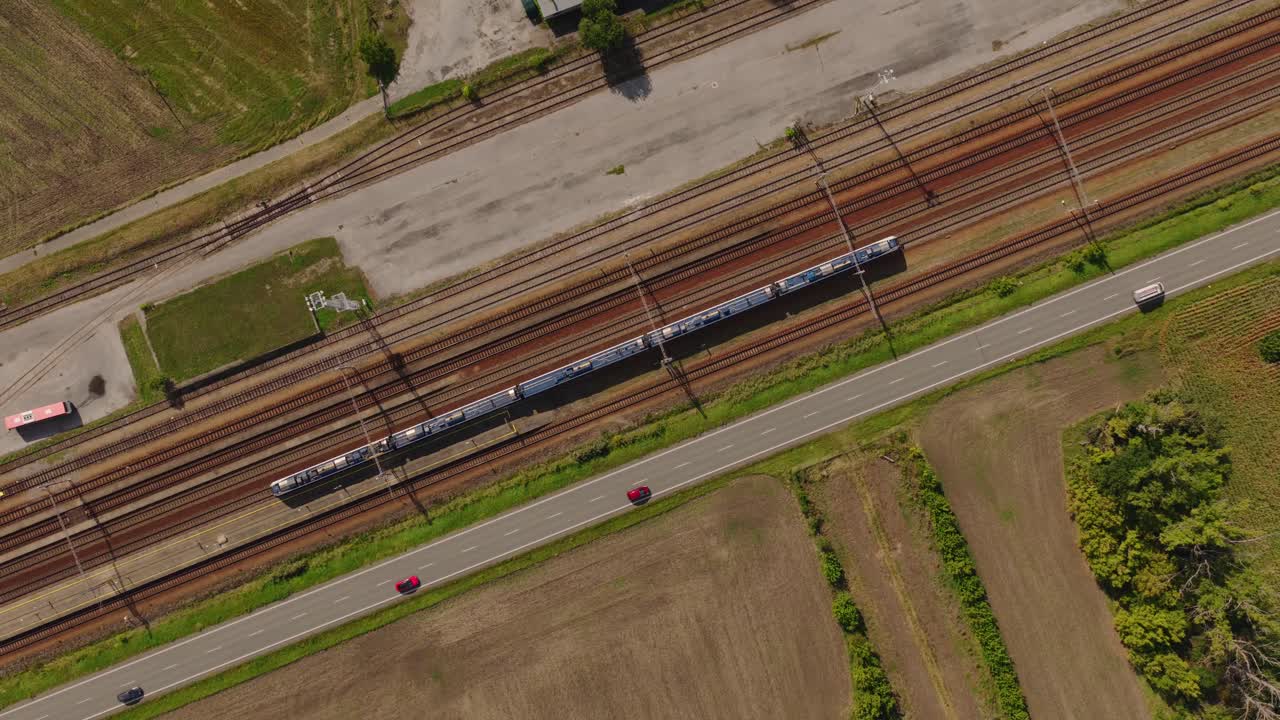 Aerial View of Train on Tracks with Cars on Road