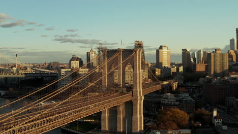 Vorwärts-Aufsteigend-Umfliegen-Brooklyn-Bridge-Mit-Massiven-Steinsäulen-Und-Tragseilen.-Stadtviertel-Im-Hintergrund.-Brooklyn,-New-York-City,-Vereinigte-Staaten