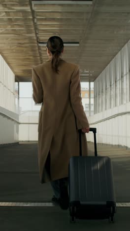 woman walking with luggage in an airport