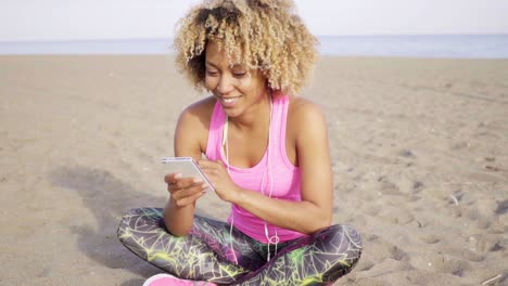 Happy-woman-sitting-on-beach-looking-to-side